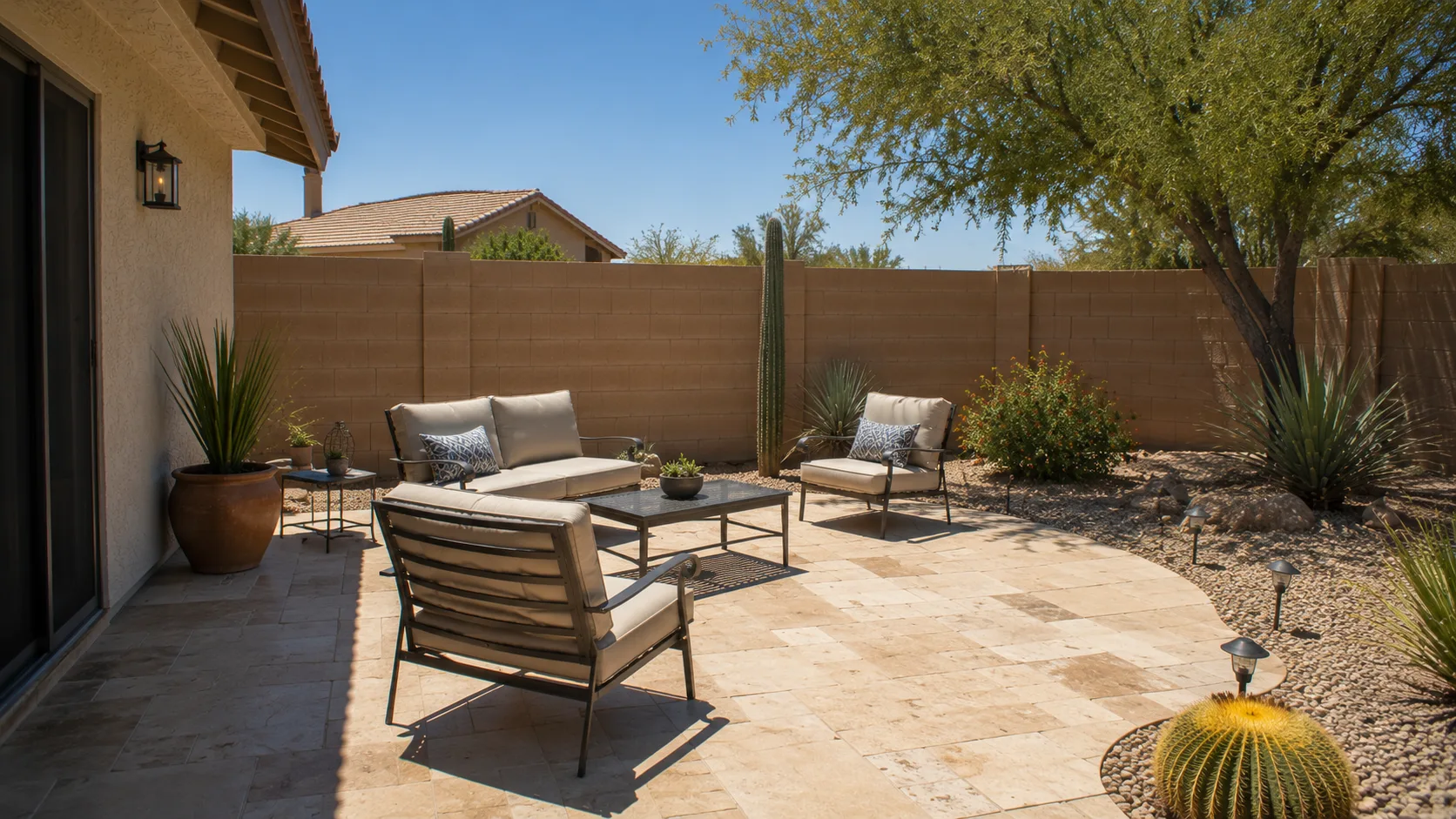 Overheated backyard patio with bright hardscape glare and too little shade for comfortable seating.