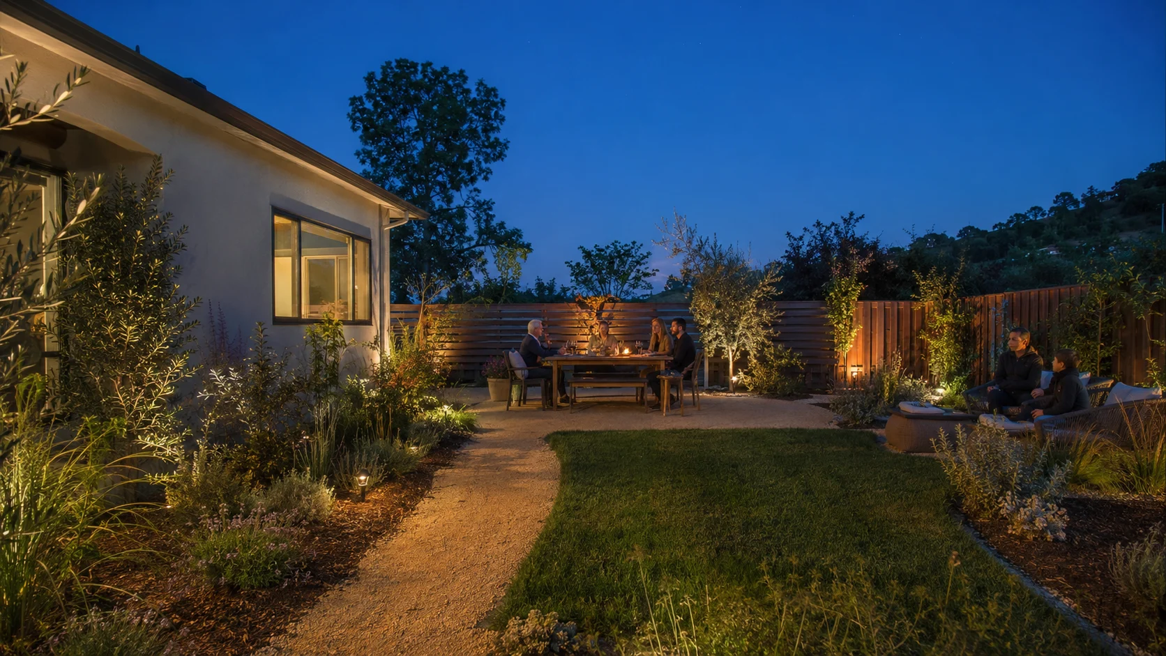 Family and friends relaxing in a backyard after part of the lawn was converted to a waterwise planting bed.